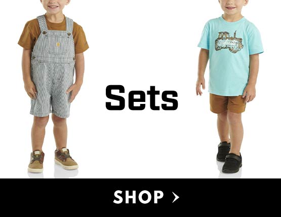 Two young boys standing on a white background wearing Carhartt sets
