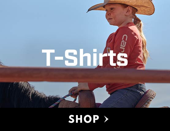 A young girl riding a horse wearing a red Carhartt t-shirt. 