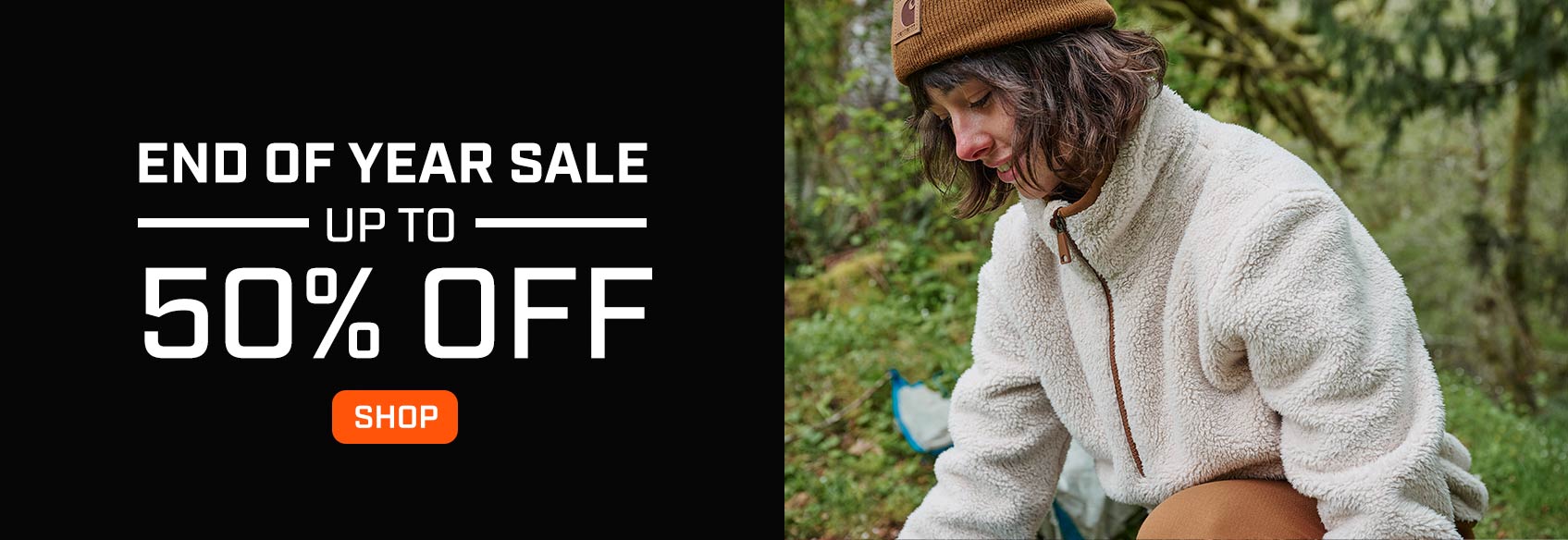 A woman in a Carhartt sweatshirt working outside.