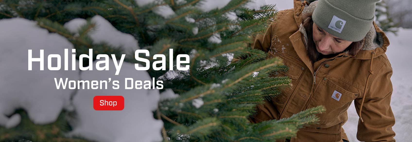 Women's Holiday Sale A woman outside in the snow wearing Carhartt clothing next to a pine tree