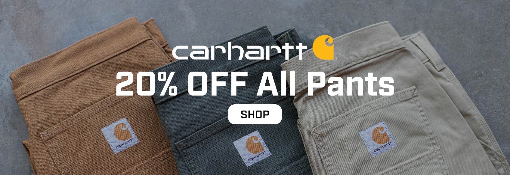 3 carhartt pants lying on the ground. 