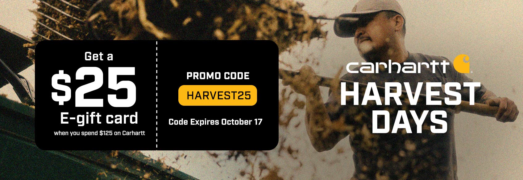 A man with a pitchfork tossing hay wearing Carhartt clothing