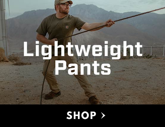 A man working in the desert wearing lightweight Carhartt pants. 