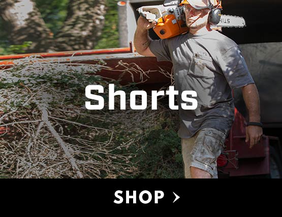 A man wearing Carhartt shorts with a chainsaw propped on his shoulder