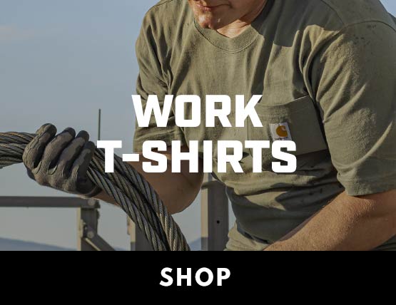 A man working outside wearing a Carhartt t-shirt and winding up steel cable.