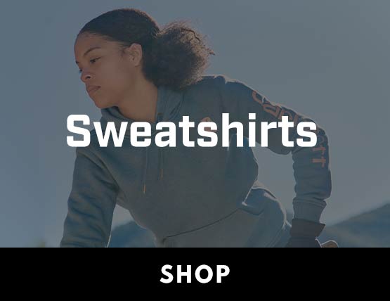 A woman working outside in a blue Carhartt sweatshirt