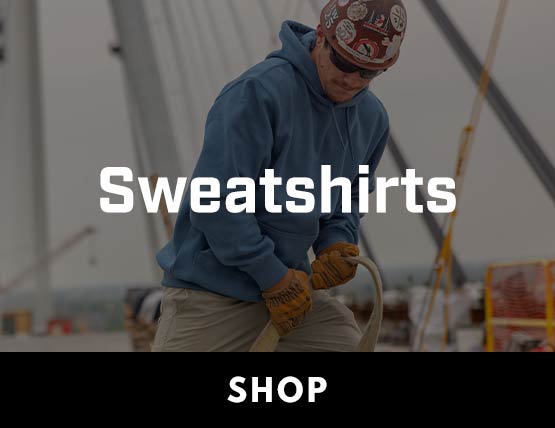 A man working on a jobsite in a hard hat wearing a blue carhartt hoodie