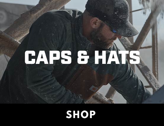 A man working in a shop wearing a ball cap. 