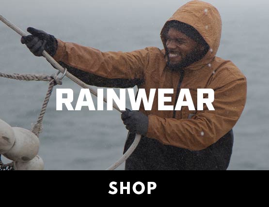 A man wearing a Carhartt rain jacket in the rain while working on a boat