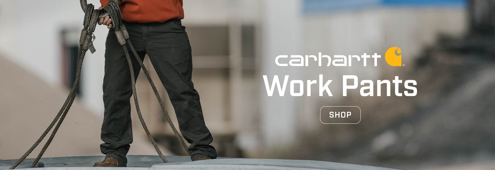 A man on a jobsite wearing Carhartt work pants and a Carhartt active jacket