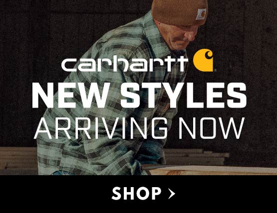 A man working in a shop wearing a Carhartt flannel shirt jac. 