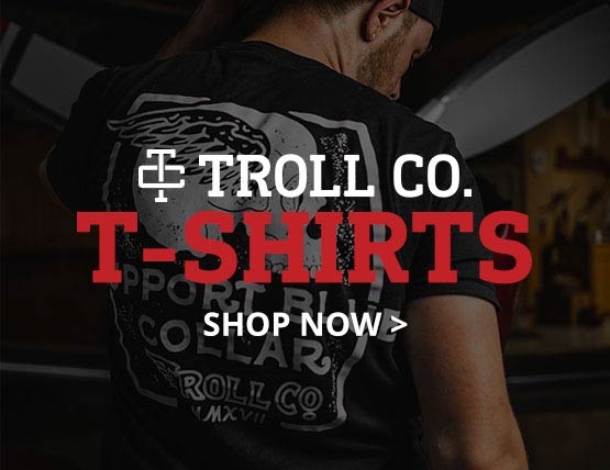 A man in a shop wearing a Troll Co. graphic t-shirt