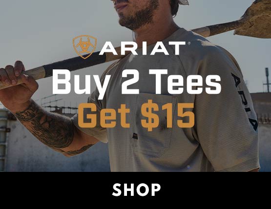A man wearing an Ariat t-shirt with a shovel over his shoulder. 
