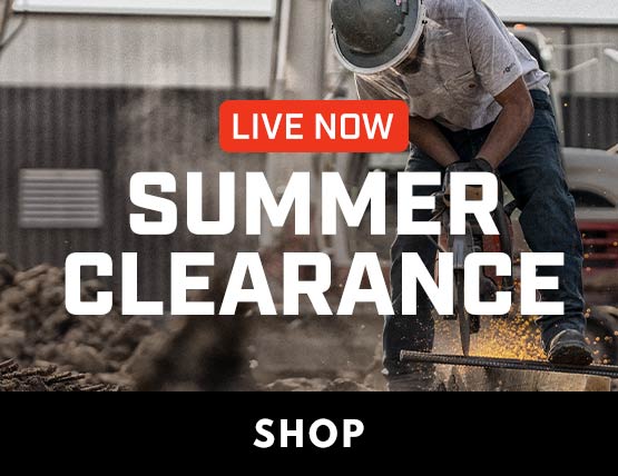 A man working outside in a Carhartt t-shirt and jeans with a hard hat. 