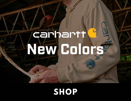 A man in a barn wearing a new Carhartt graphic hoodie.