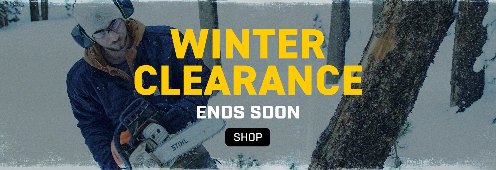 A man in a denim Carhartt jacket working in the snow - Winter Clearance Ends Soon