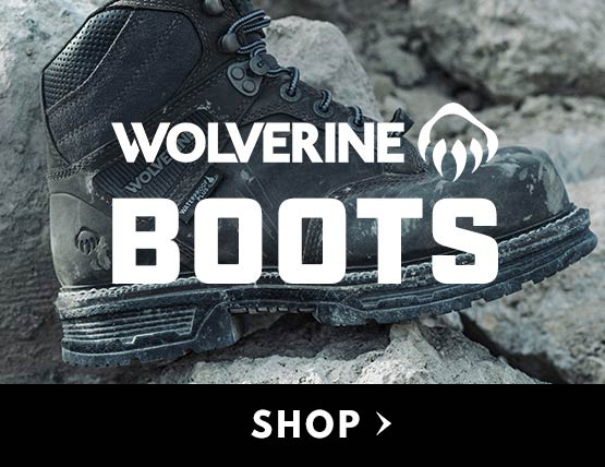 A pair of wolverine boots sitting on rocks