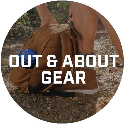 A Carhartt backpack sitting a man's feet